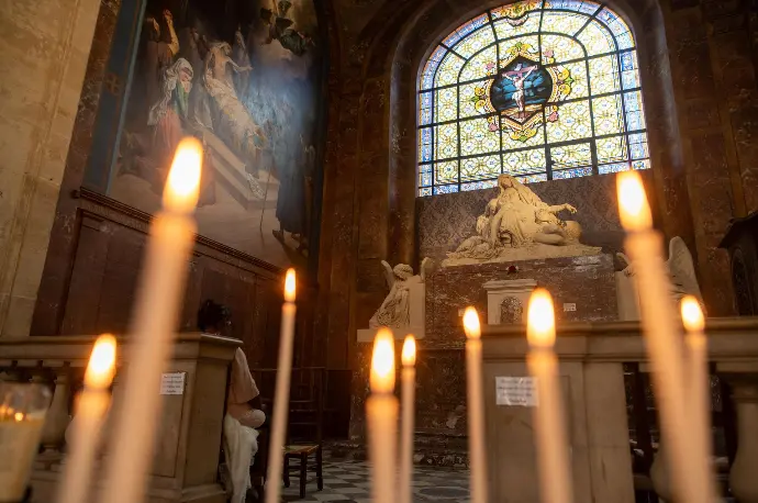 Hôtel de la chapelle des ames du purgatoires avec la statue de la pieta en arrière plan, et des cierges en premier plan